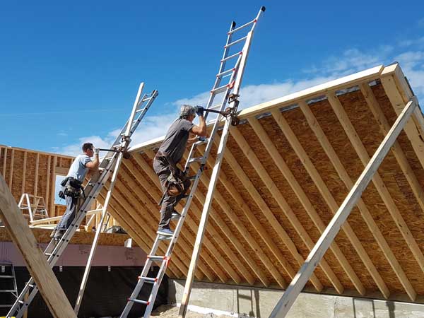 Two men raising a wall on a construction site